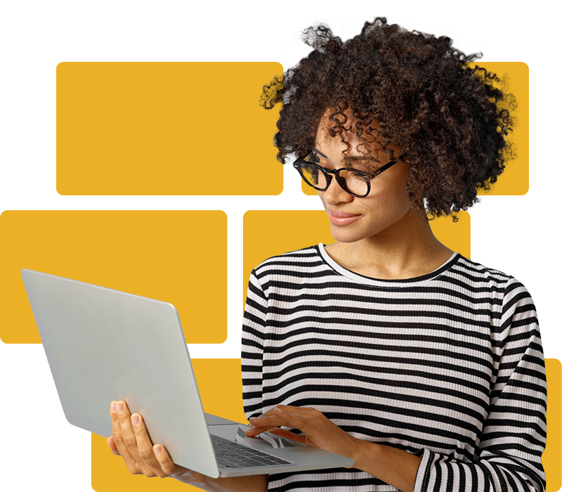 A woman wearing glasses and looking down at their laptop.