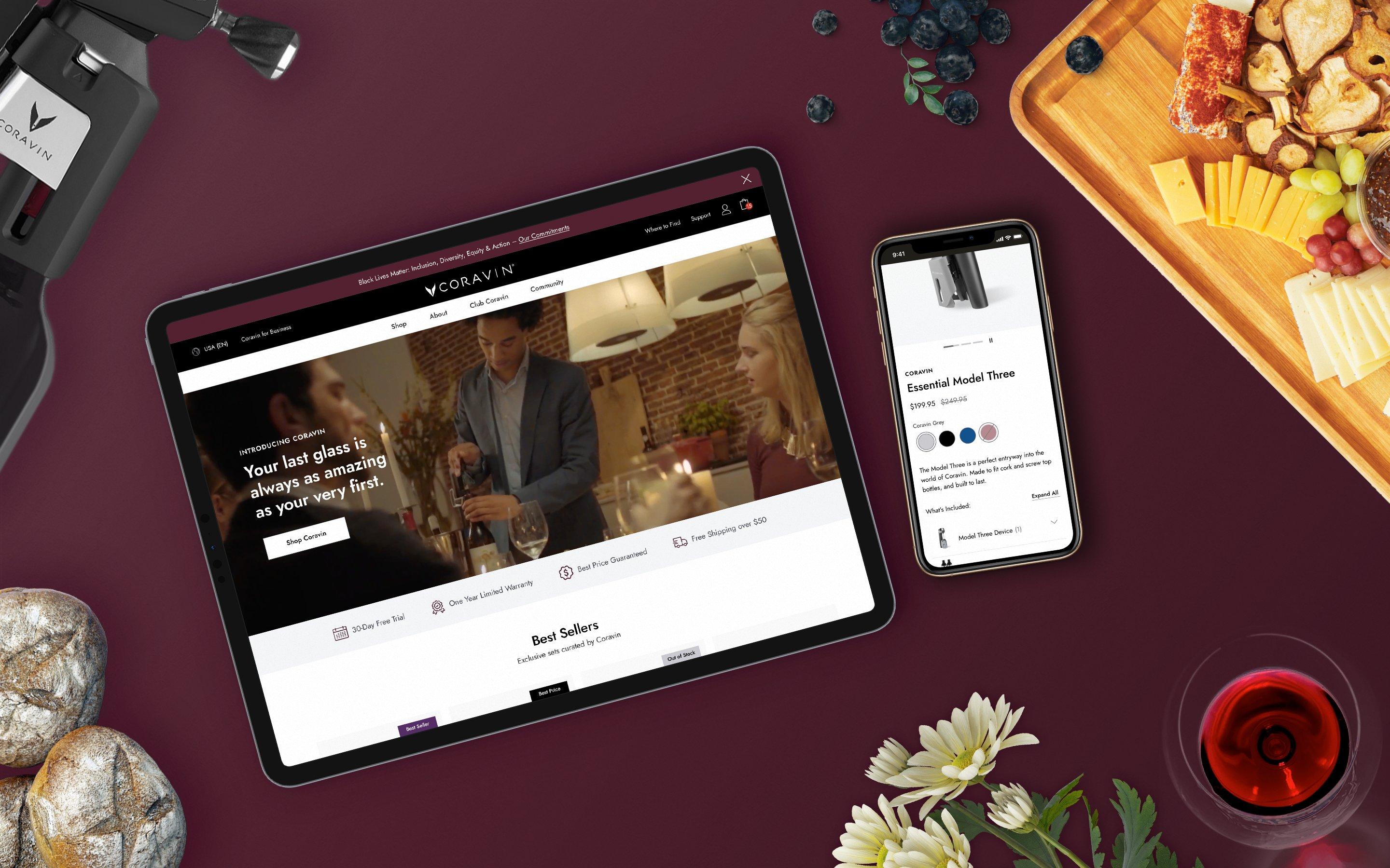 Flatlay of Coravin website on an iPad and iPhone surrounded by rolls of bread, a wine glass, a chacuterie board and a wine bottle opener.